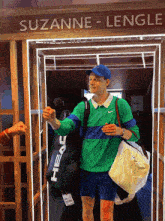 a man in a green shirt and blue hat is walking through a doorway with the name suzanne lengle written on it