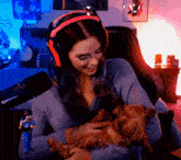 a woman wearing headphones holds a small dog in her arms in front of a shure microphone