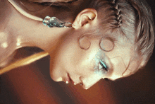 a close up of a woman 's face with makeup and earrings on