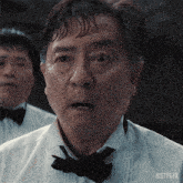 a man wearing a bow tie and a white shirt has netflix written on the bottom right