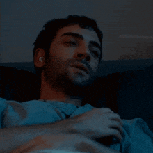 a man with ear plugs in his ears is laying down