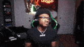 a man wearing headphones and glasses is sitting in front of a microphone .