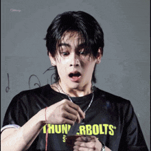 a person wearing a black shirt that says thunderbolts on it