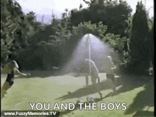 a group of people are playing frisbee in a field with the words `` you and the boys '' written in the corner .