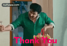 a man in a green shirt is holding a bag of food in his hands and saying `` thank you '' .