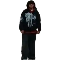 a man wearing a black hoodie with a cross on it is standing in front of a white background .