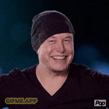 a man wearing a beanie and a black shirt is laughing and pointing at the camera .