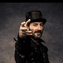 a man with a beard wearing a top hat and a leather jacket