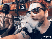 a man with a tattoo on his arm is smoking a cigarette