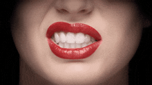 a closeup of a woman 's mouth with red lipstick and white teeth
