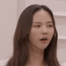 a woman with long brown hair is making a funny face .