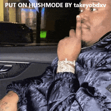 a man is sitting in a car with his finger on his lips and the caption put on hushmode by takeyobdxv