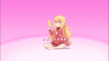 a girl with long blonde hair is sitting on the floor holding a yellow object