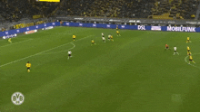 a soccer game is being played in front of a banner that says ' t & t ' on it