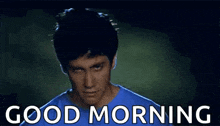 a man in a blue shirt is making a funny face and saying `` good morning '' .