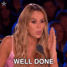 a woman in a pink top is giving a high five and the words well done are behind her