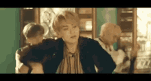 a group of young men are dancing together in a room in front of a mirror .
