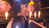 a man is walking down a stage with flames behind him and a sign that says mgm on it