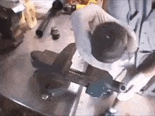 a man is working on a piece of metal with a vice