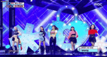 a group of girls are standing on a stage in front of a heart shaped sign that says mbc