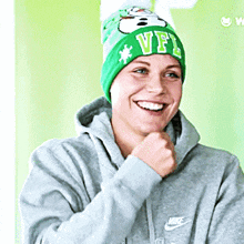 a woman wearing a hoodie and a green hat with the letter vfl on it