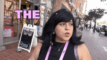 a woman standing in front of a store with the word the above her head
