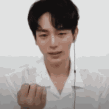 a man wearing headphones and a white shirt is making a fist .