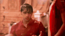 a man in a red shirt is standing next to a woman in a red shirt .