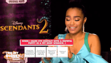 a woman is smiling in front of a poster for disney 's descendants 2