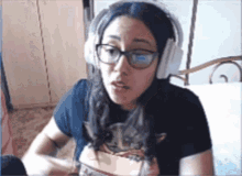 a woman wearing glasses and headphones is making a face