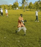 a man wearing a mask and gloves is running in a grassy field
