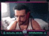 a man with a beard is sitting on a bed looking at the camera .
