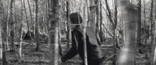 a person is walking through a forest with a rope around their neck .
