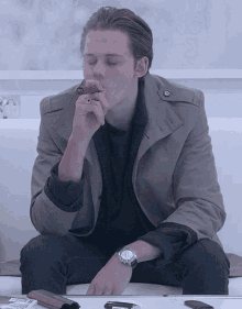 a man sitting on a couch smoking a cigar