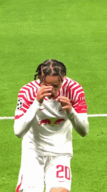 a soccer player with the number 20 on his shorts is walking on the field