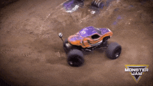 an orange and purple monster jam truck is driving through the dirt