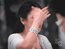 a woman is covering her face with her hand and the letters sc are below her