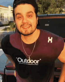 a man wearing a purple shirt that says " outdoor "