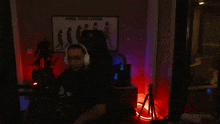 a man wearing headphones sits in front of a sign that says king evolution