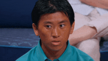a man in a blue shirt is looking at the camera