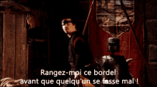 a man standing in a dark room with the words rangez-moi ce bordel written on the bottom
