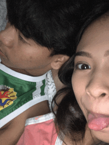 a girl sticking her tongue out next to a boy wearing a shirt that says ' philippines '