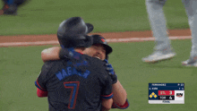 two baseball players hugging each other with a scoreboard in the background that says fernandoz