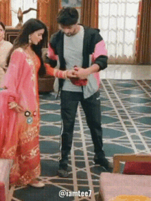 a man and a woman are standing on a rug in a living room .