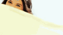 a woman in a yellow dress is smiling and wearing a headband .