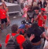 a crowd of people are gathered on a street including a man dressed as spiderman .