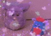 a purple furby and a blue furby are surrounded by glitter