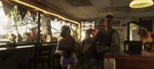 a group of people are dancing in a bar with a sign that says ' z & n ' on it