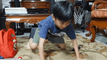 a young boy is doing push ups on a rug in a living room .