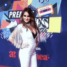 a woman in a white jumpsuit stands on a red carpet in front of a sign that says " prep "